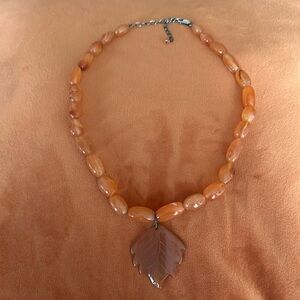 Beautiful orange jade necklace with leaf pendant.